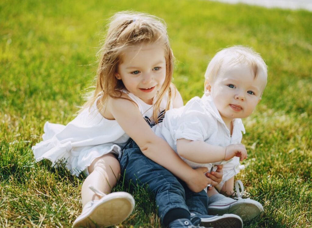 testvérek játszanak a fűben