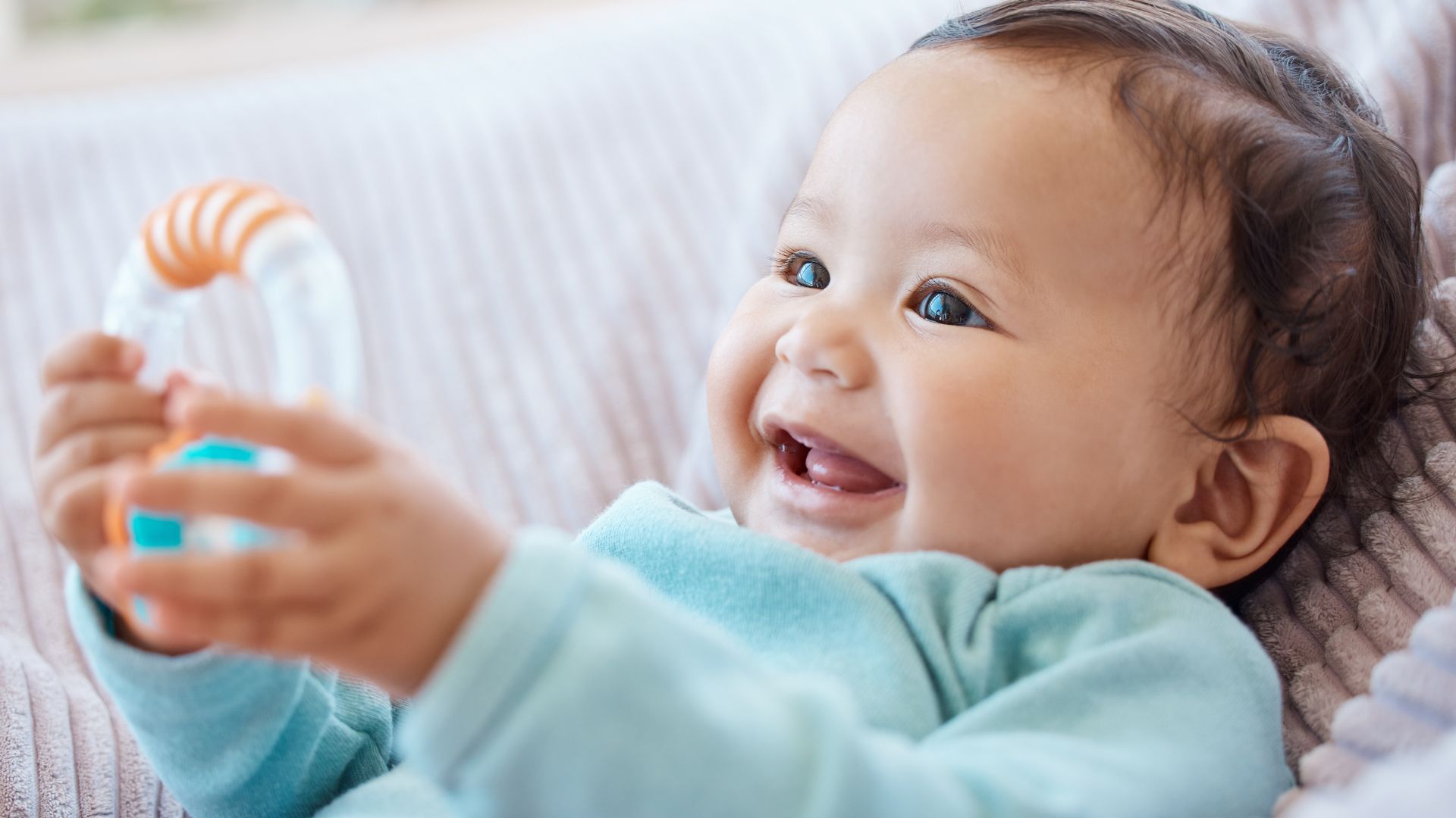 Első babaszoba berendezése: kisbaba mosolyog a babaágyon fekve.